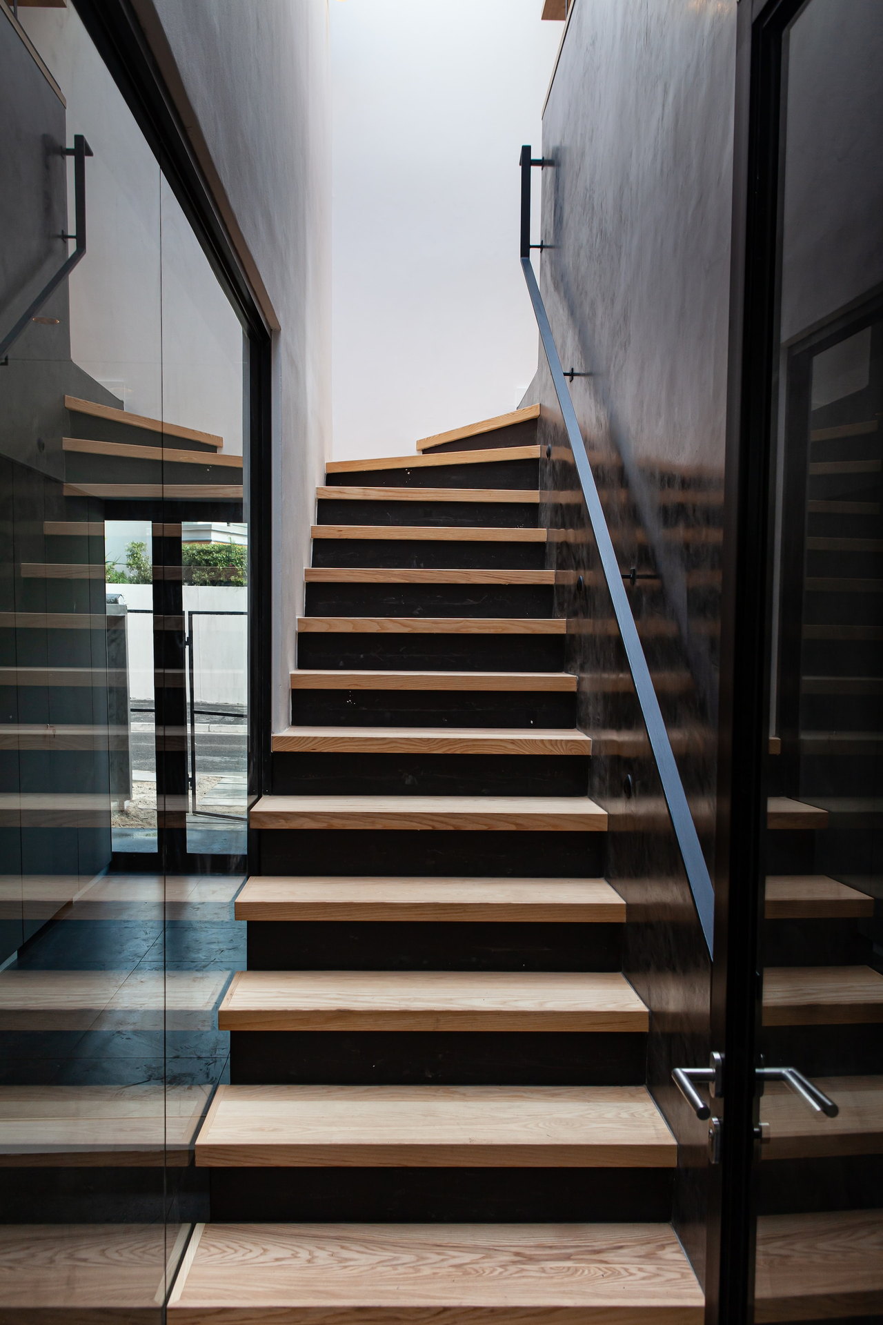 Holztreppe mit schwarzem Geländer