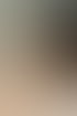 Frau mit dunklen Haaren legt sich Ohrringe an und trägt eine Perlenkette sowie einen Ring mit drei Steinen.