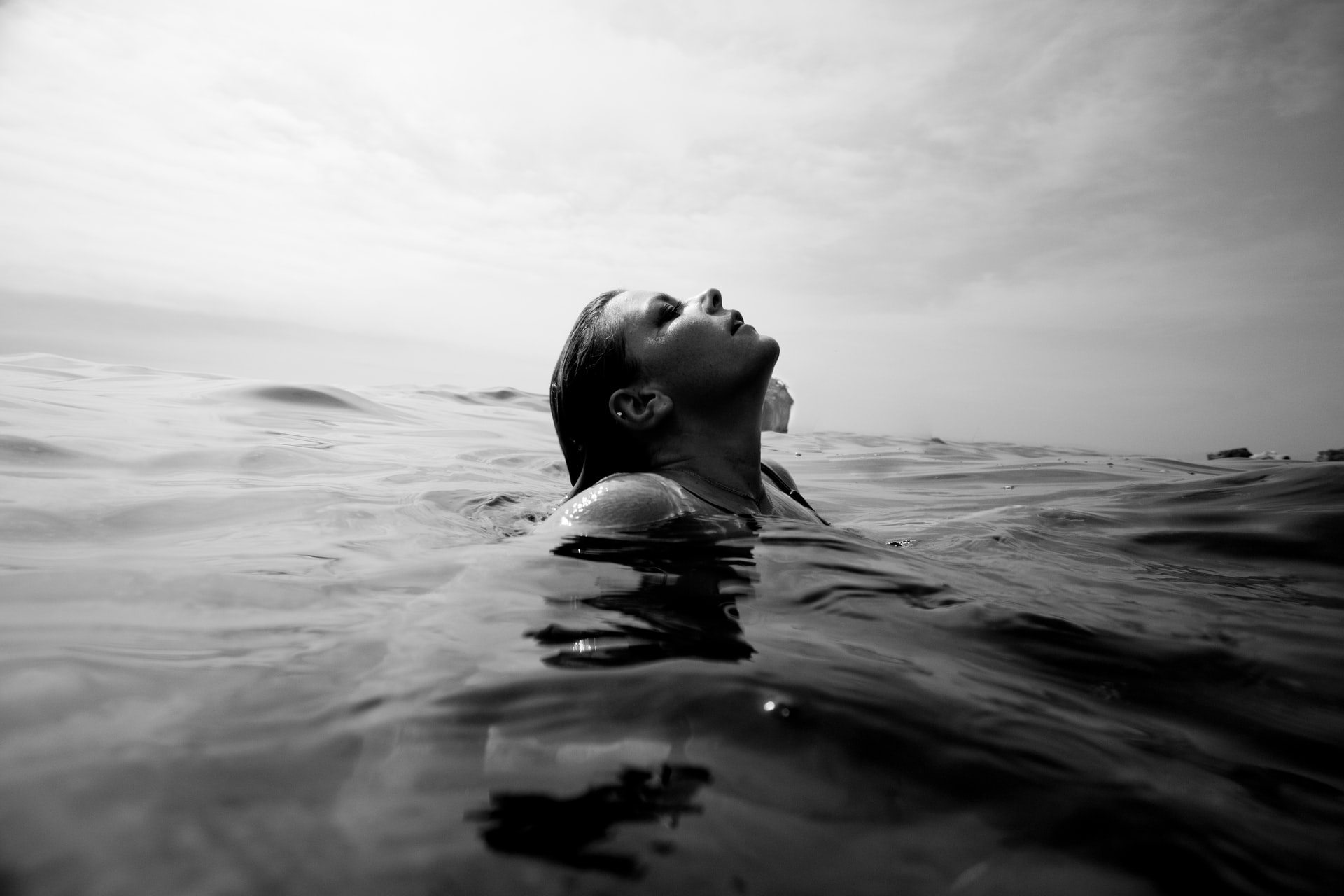 Frau treibt im Meer, das Gesicht halb über der Wasseroberfläche