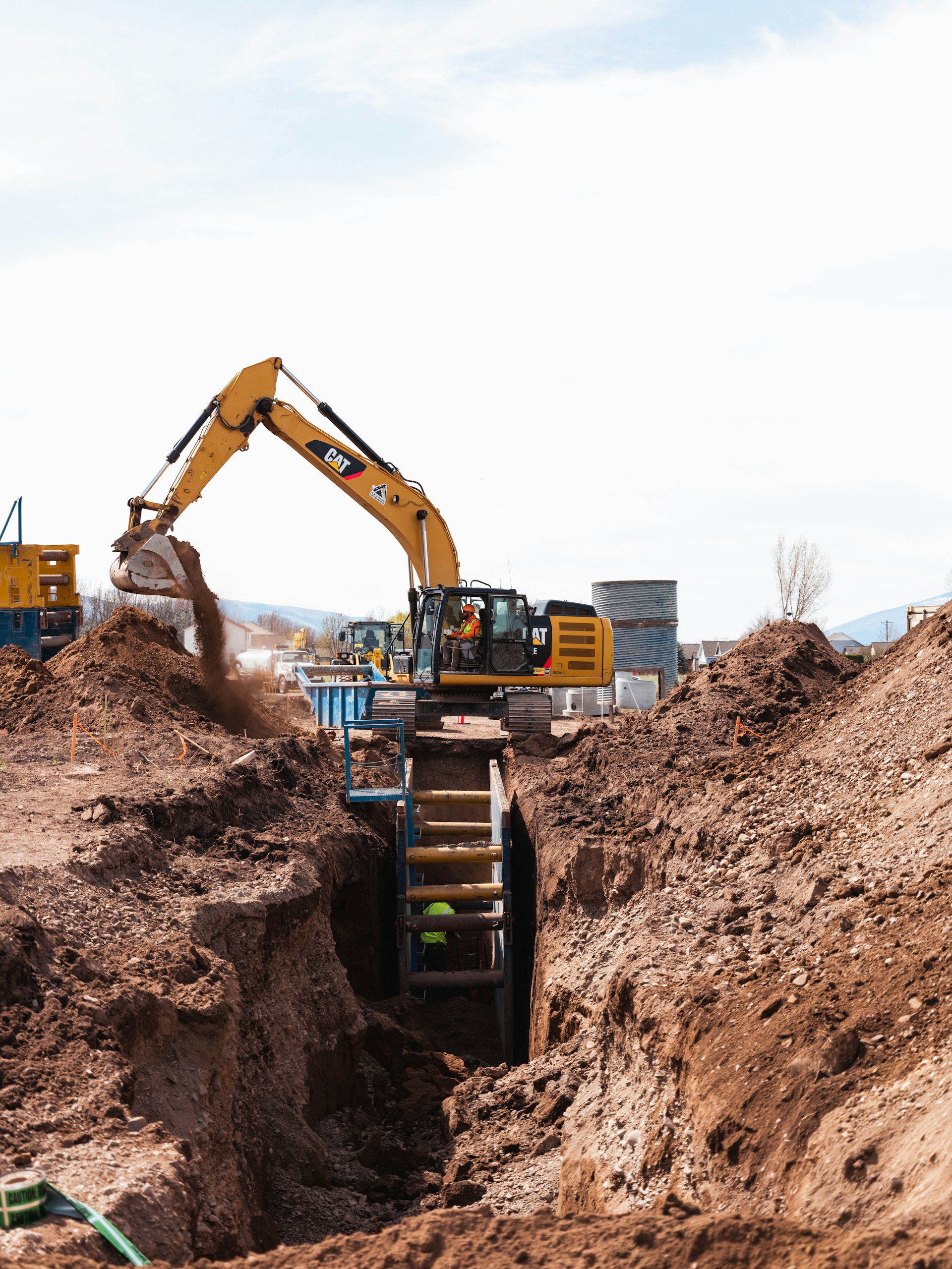 Bauarbeiter an einer Tiefbau-Baustelle mit Kompaktbagger