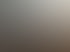 Blick über Dächer weißer Wohnhäuser bei Sonnenaufgang mit tiefstehender Sonne und blauem Himmel.