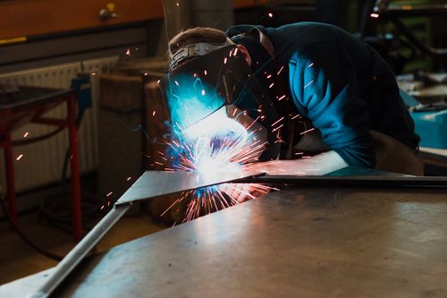 Fachkraft bei der Metallbearbeitung mit Funkenflug