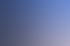 Ein lächelnder Umzugshelfer hält einen Karton, während drei weitere Helfer im Hintergrund Kartons packen.