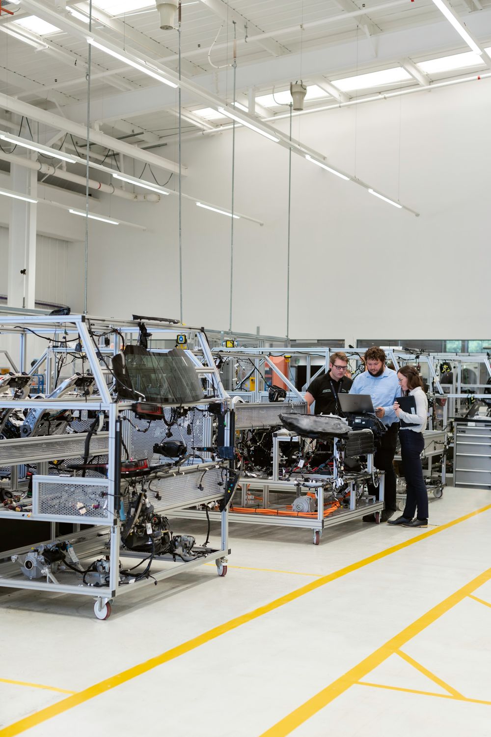 Technikteam bespricht Arbeiten an Anlagengestellen in einer hellen Industriehalle