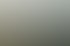 Grüne, bewaldete Hügel umgeben eine kleine Stadt mit roten Dächern unter einem hellen Himmel bei Sonnenuntergang.