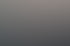 Eine braune Brille liegt auf einem Felsen am Wasser bei Sonnenuntergang.