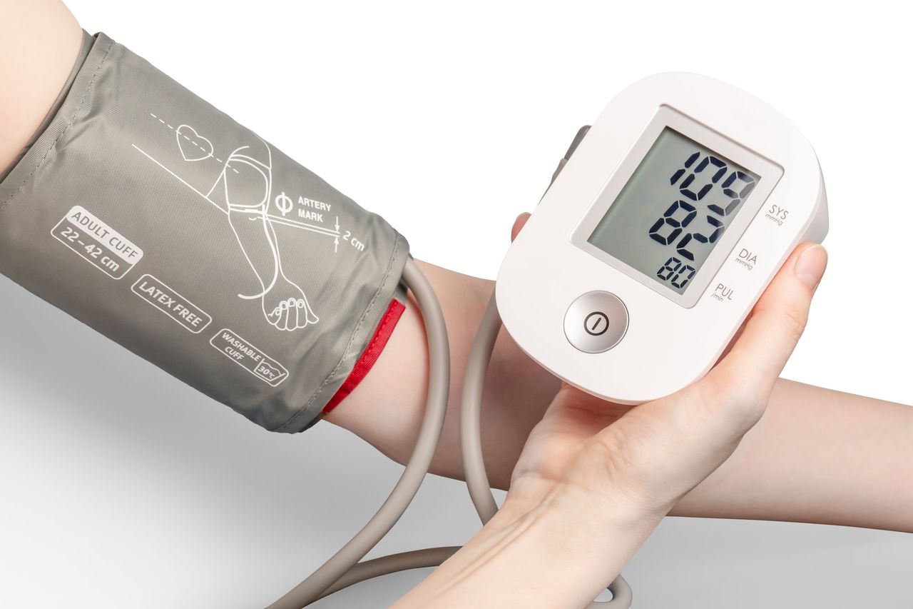 Blutdruckmessung am Arm einer Person mit digitalem Blutdruckmessgerät in der Elefanten Apotheke Hamburg
