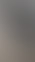 Ein lächelnder Kfz-Mechaniker mit Mercedes-Benz-Logo auf dem Hemd hält ein Diagnosetool neben einem Auto mit geöffneter Motorhaube.